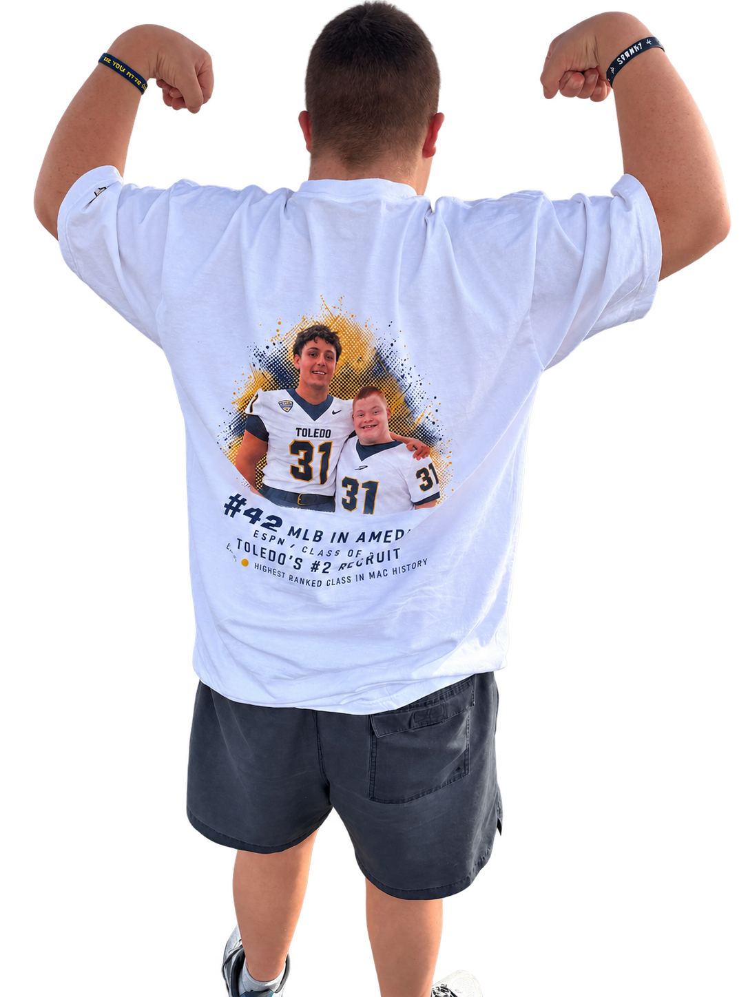 Back — Micah showing the brothers artwork on the back of the shirt, both arms raised