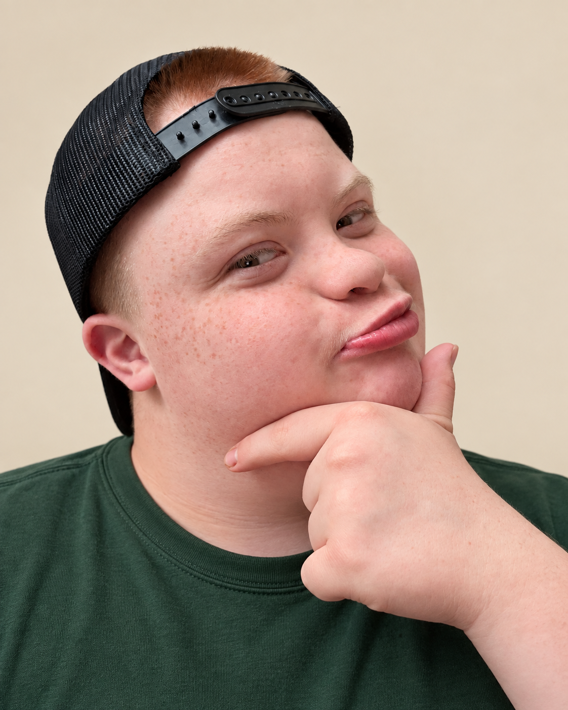 Micah, CEO of Micah Made, wearing a backward cap and green tee with his hand resting under his chin